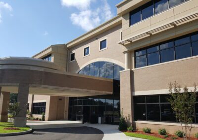 The entrance to a large building with a parking lot.