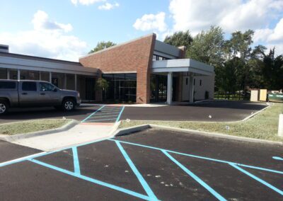 A parking lot with a blue line in front of a building.